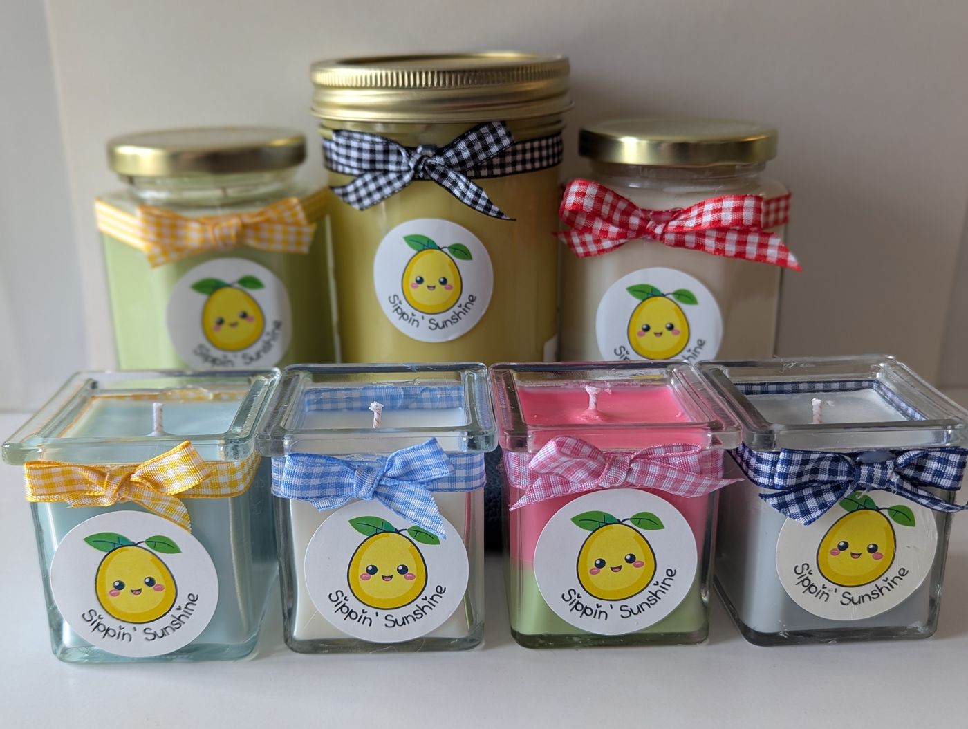 A colorful collection of handmade Sippin' Sunshine candles — lemonade, matcha, and iced coffee scents