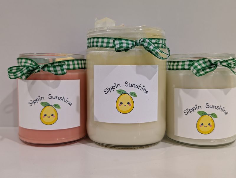 Medium and large handmade Sippin' Sunshine candles in colorful vessels